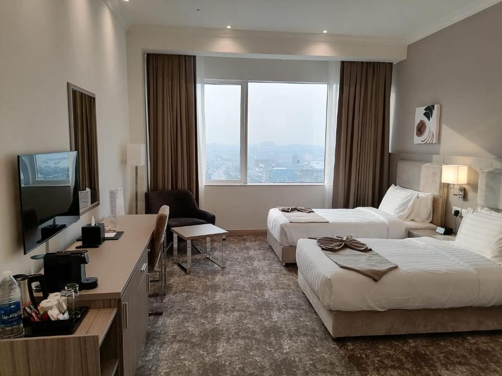 Postel nebo postele na pokoji v ubytování Gloria Hotel & Suites Doha