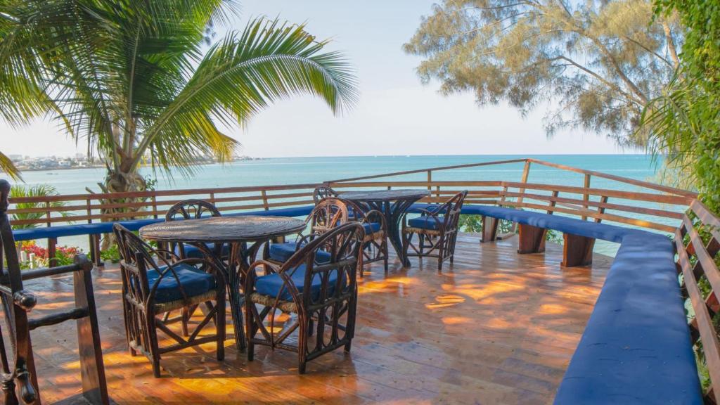a patio with tables and chairs and the ocean at Hostería Ecológica El Faro in Salinas