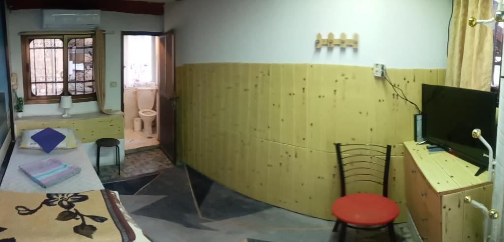 a room with a wooden wall with a desk and a television at Jaffa Gate Hostel in Jerusalem