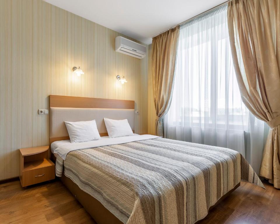 a bedroom with a large bed and a window at Гостиница Siesta Киев in Kyiv