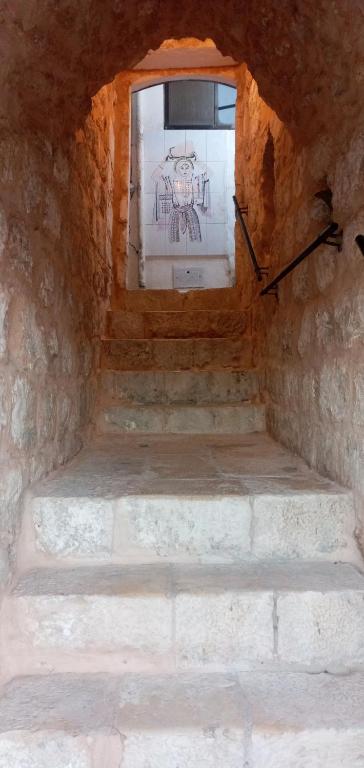 a window in a stone room with stairs in front at Jaffa Gate Hostel in Jerusalem