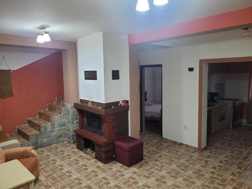 - un salon avec une cheminée et un escalier dans l'établissement Cabana Rustic, à Cavnic