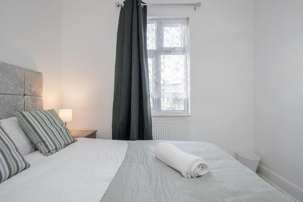a bedroom with a white bed with a large window at TMS Top Flat! Tilbury! in Tilbury