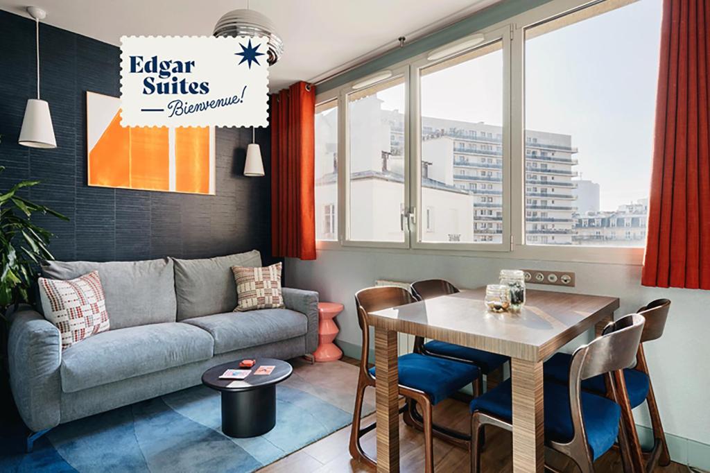Hotel Edgar Suites Expo Paris Porte de Versailles, a living room with a couch and a table at Edgar Suites Expo Paris Porte de Versailles in Paris