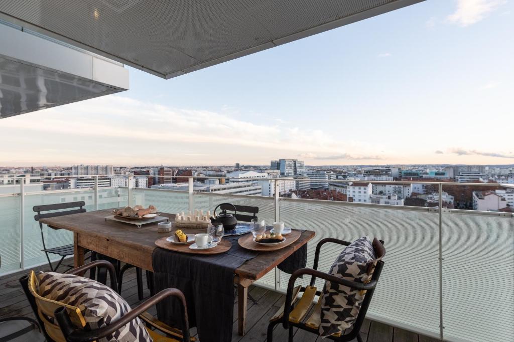 une table sur un balcon avec vue sur une ville dans l'établissement Sky Avenue - Magnifique T2 avec vue époustouflante, à Lyon
