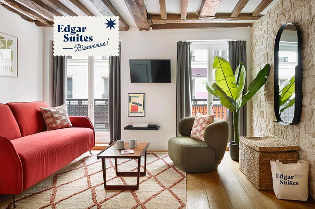 a living room with a red couch and a chair at Edgar Suites Montorgueil - Caire in Paris