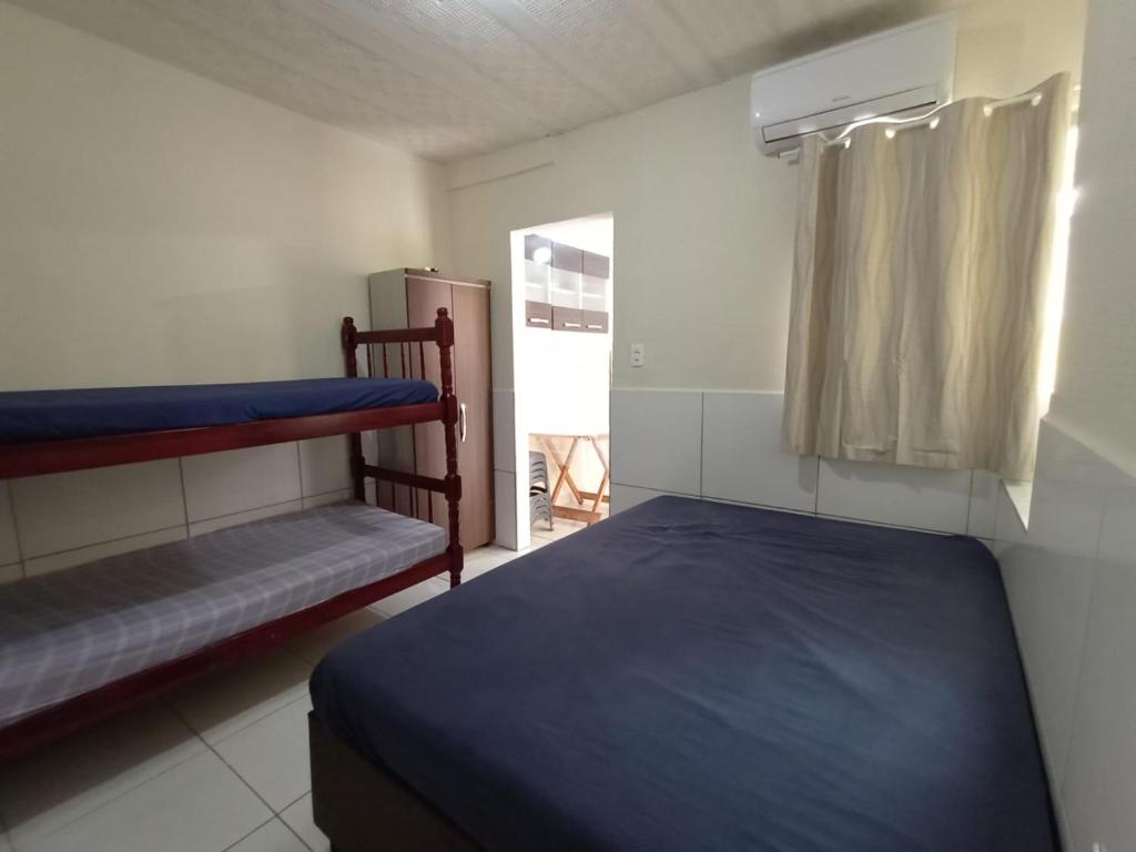 a bedroom with two bunk beds and a window at Kitnets Recanto Caiobá in Matinhos