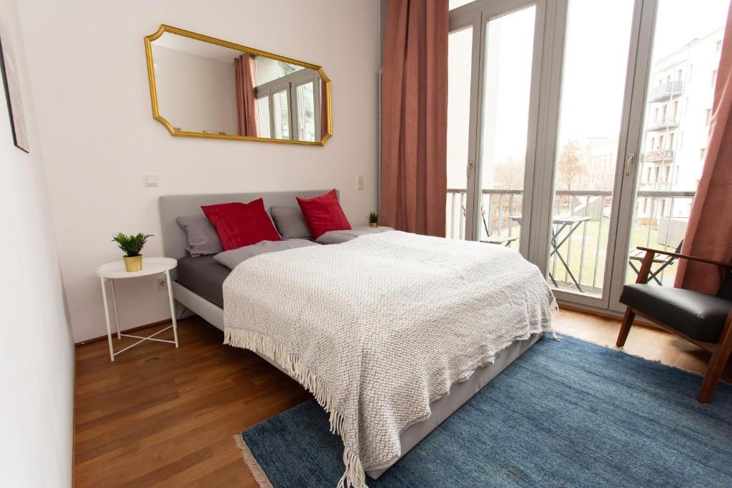 a bedroom with a bed and a mirror on the wall at FULL HOUSE Premium Apartments Leipzig M14 in Leipzig