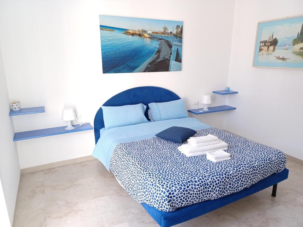una camera da letto con un letto blu e asciugamani di La casa del Gabbo apartment a Monopoli