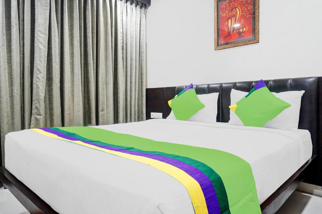 a bedroom with a bed with a rainbow blanket at Treebo Trend Madhuvan Grand in Vijayawāda