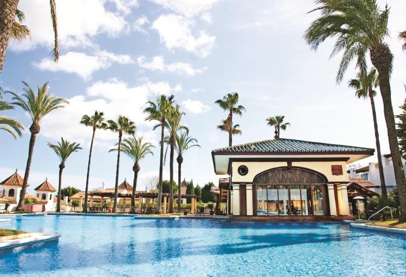 - une piscine dans un complexe avec des palmiers dans l'établissement Inmood San Roque, à Sotogrande