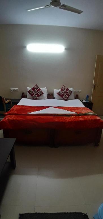 een slaapkamer met een groot bed met rode lakens en kussens bij Brookefield Service Apartment in Bangalore