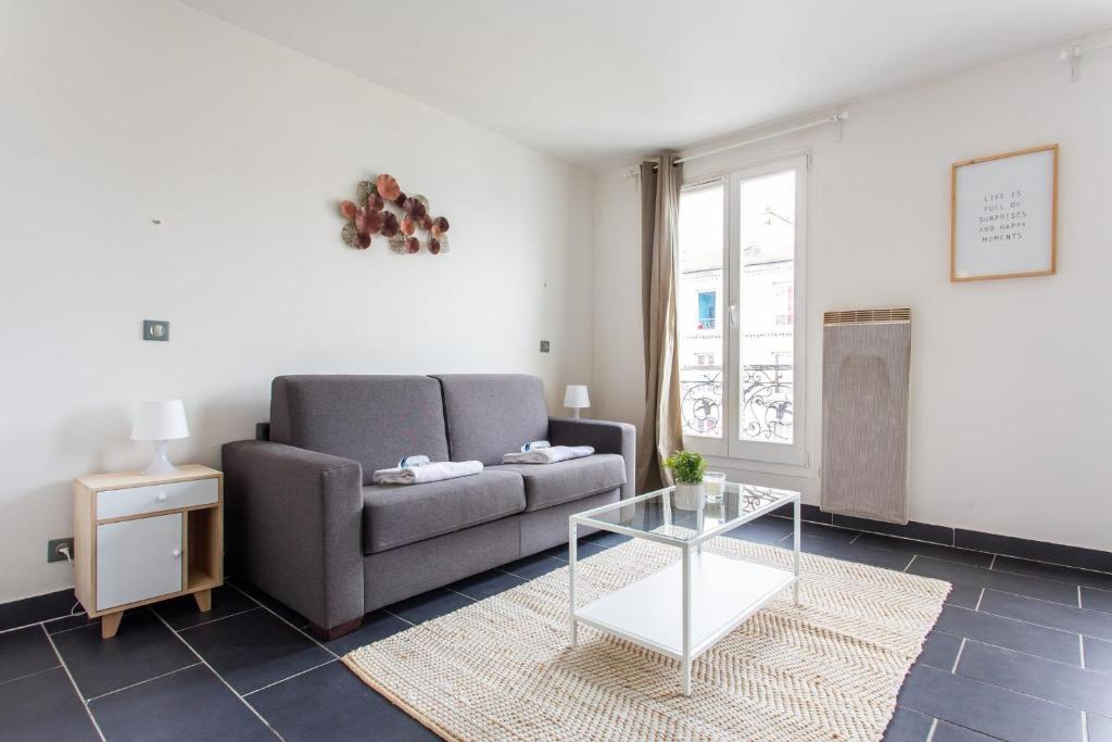 a living room with a couch and a table at CMG - Résidence Edouard Vaillant in Pantin