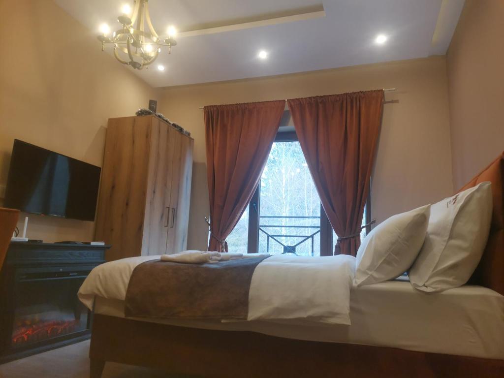 a bedroom with a bed and a large window at Golden Mountain A75 NLux Milmari in Kopaonik