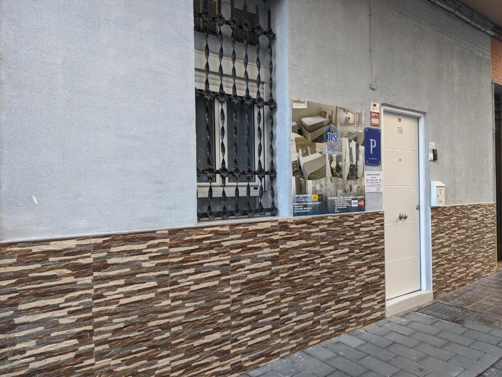 a building with a door and a window with boxes at Pension Susita in Alicante