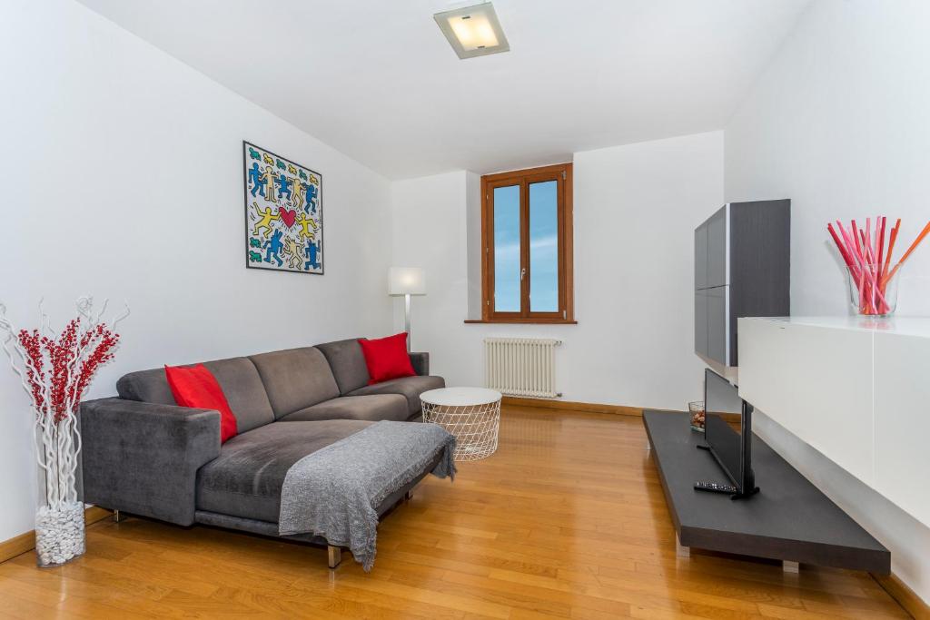 Una sala de estar con un sofá y un televisor. en Corte Baldissera Udine Centro, en Udine