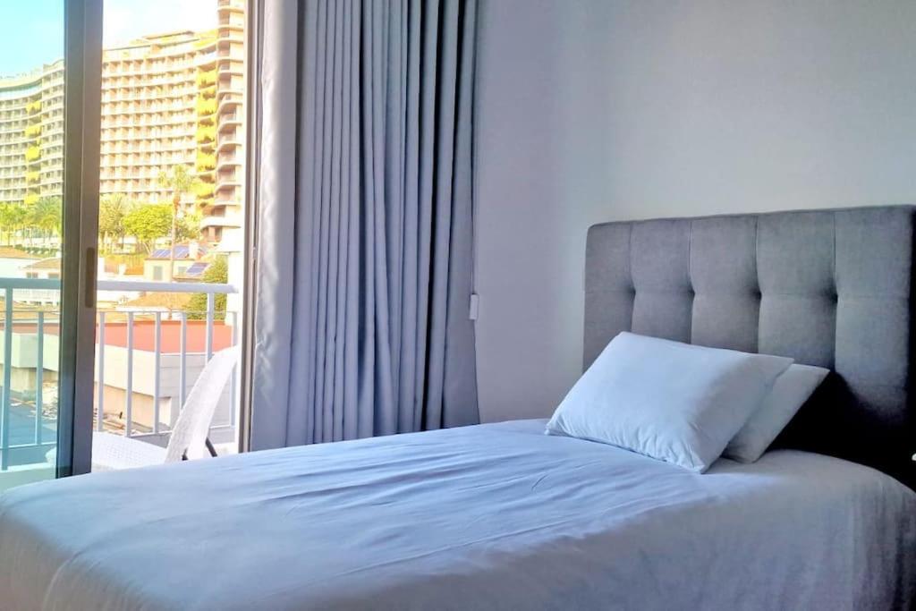 1 dormitorio con cama y ventana grande en Ocean Pearl Apartment V, en Funchal