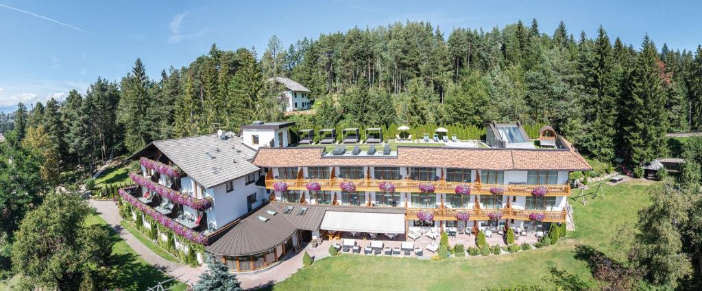 eine Luftansicht eines großen Hauses auf einem Hügel in der Unterkunft APIPURA hotel rinner in Oberbozen