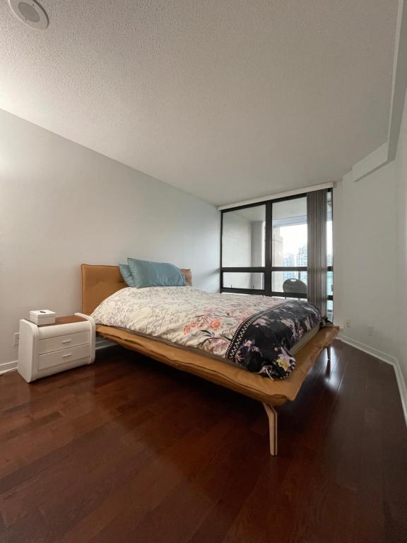 Vancouver Downtown Central 1 bedroom Condo في فانكوفر: غرفة نوم بسرير كبير ونافذة