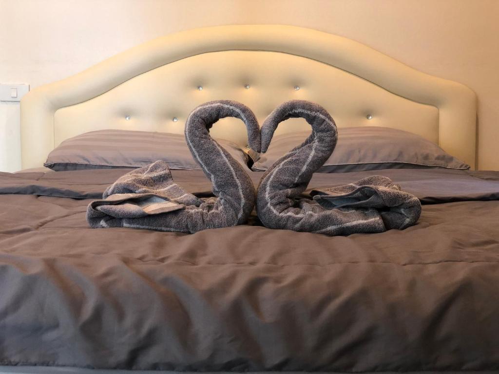 - deux cygnes assis sur un lit avec des serviettes dans l'établissement Blue house beach apartment, à Ban Pa Khan