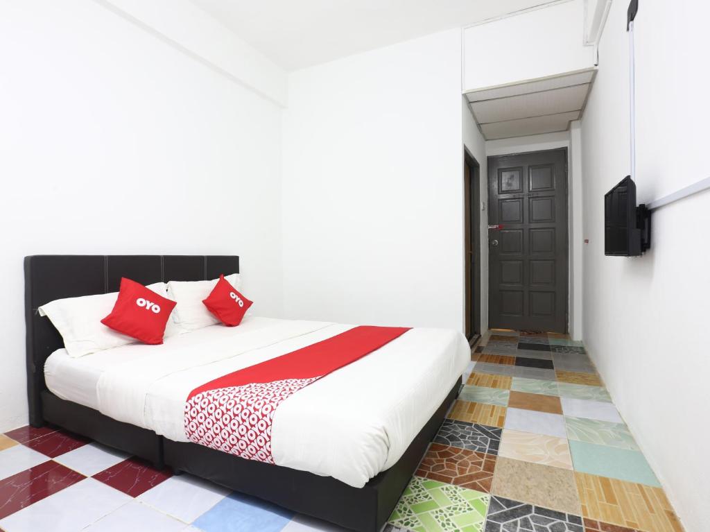 a bedroom with a bed with red pillows at Kb Rest Inn-Deluxe Queen in Kota Bharu
