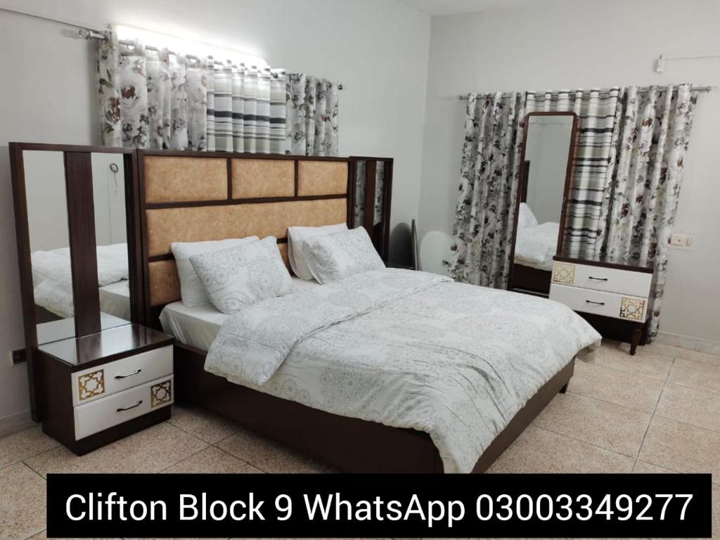 a bedroom with a large bed and two mirrors at Karachi Guest House & Couple Hotel in Karachi