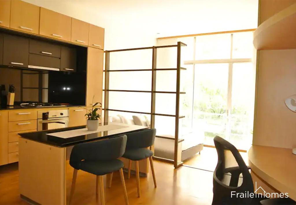 una cocina con una isla con sillas y una mesa en FH - Stylish loft in Chico Norte - Bogota, en Bogotá