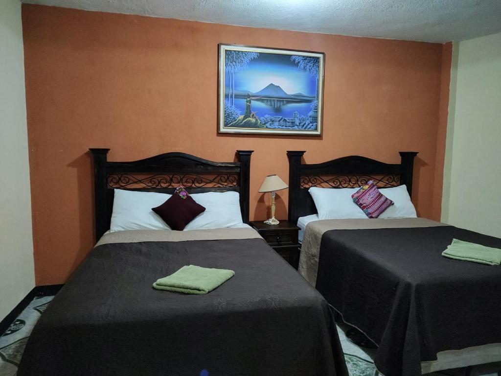 Habitación de hotel con 2 camas y una foto en la pared en Casa Elefante Dormido, en Panajachel