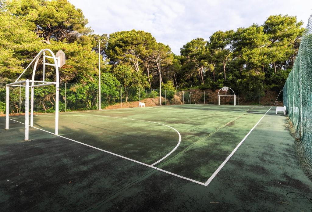 a tennis court with a basketball hoop on it at Belambra Clubs Presqu&#39;île De Giens - les Criques in Hyères