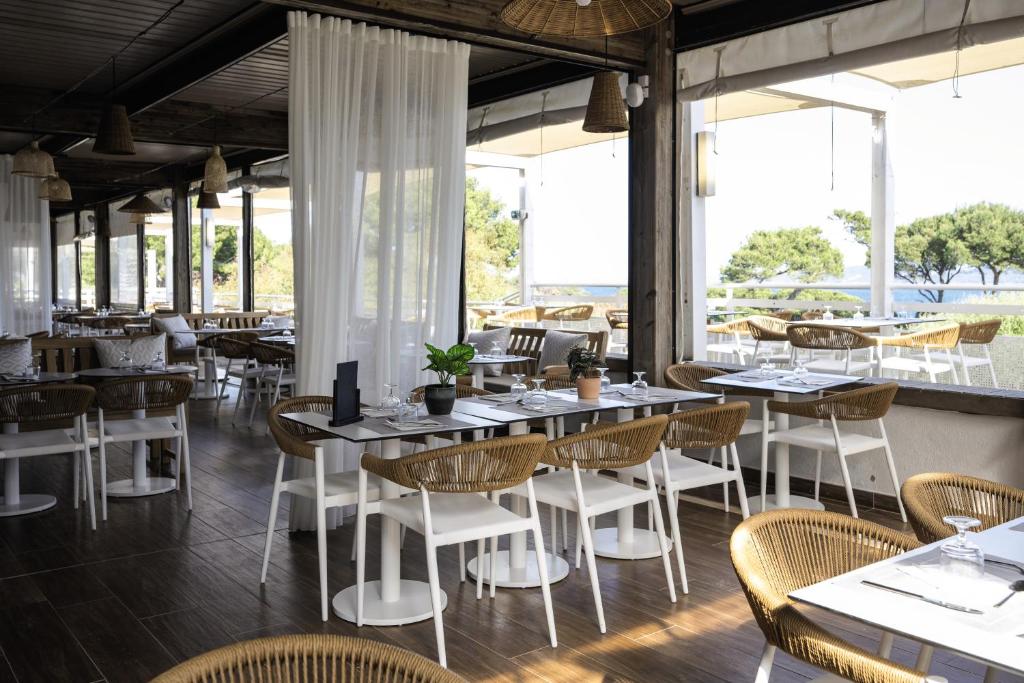 a restaurant with tables and chairs and windows at Belambra Clubs Presqu&#39;île De Giens - les Criques in Hyères