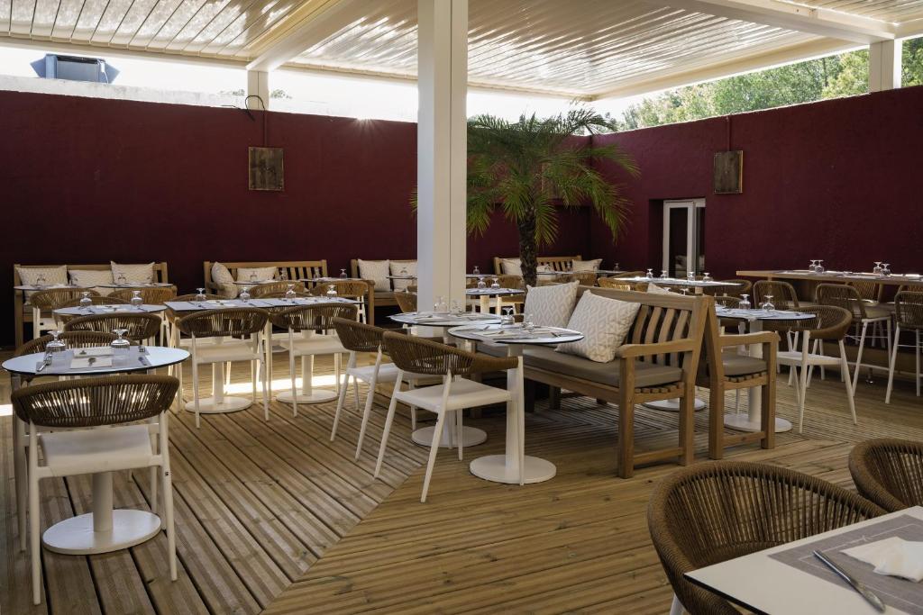 a restaurant with tables and chairs in a room at Belambra Clubs Presqu&#39;île De Giens - les Criques in Hyères