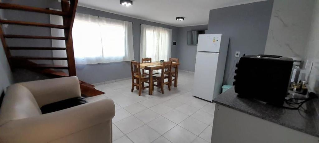 cocina y sala de estar con sofá y mesa en Departamento La Tercera en San Clemente del Tuyú