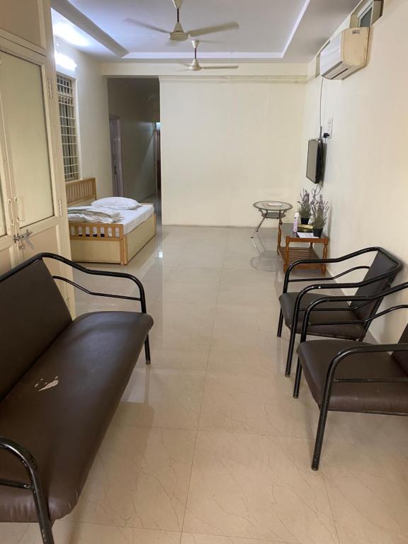 a room with chairs and a couch and a bed at Simhagiri Holiday Inn in Visakhapatnam