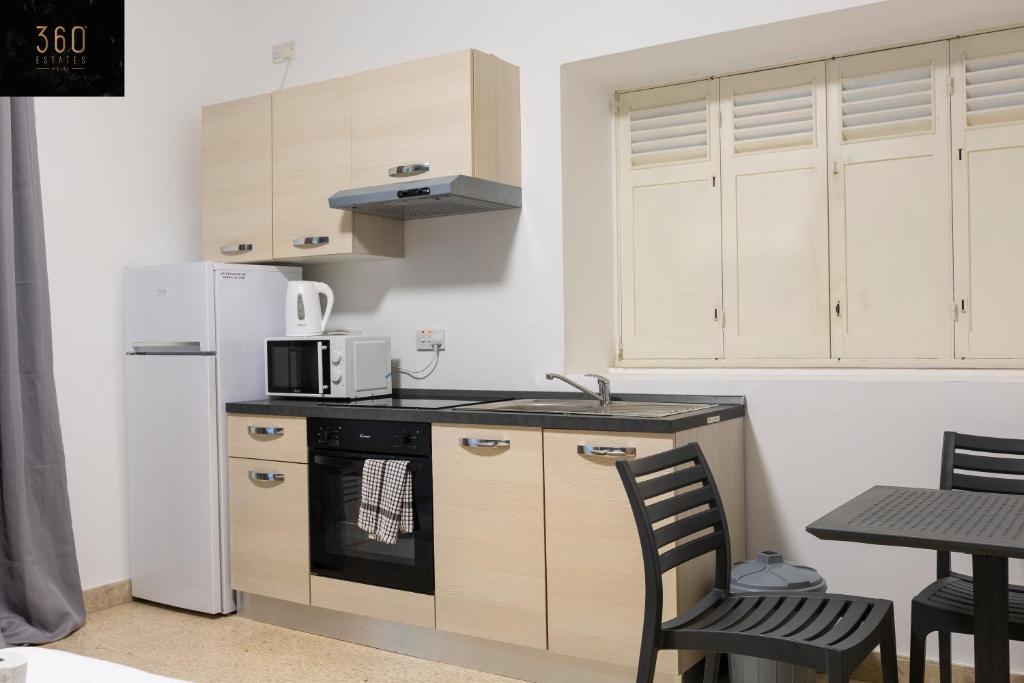 a kitchen with a refrigerator and a stove top oven at Spacious NUM1 house in Swieqi - Sleeps 18 w&#47;WIFI by 360 Estates in Is-Swieqi
