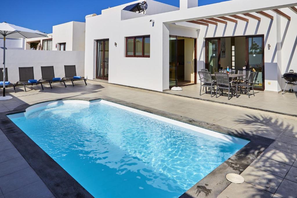 una piscina en el patio trasero de una casa en Villa Cantium - LH101 By Villas Now Ltd, en Playa Blanca