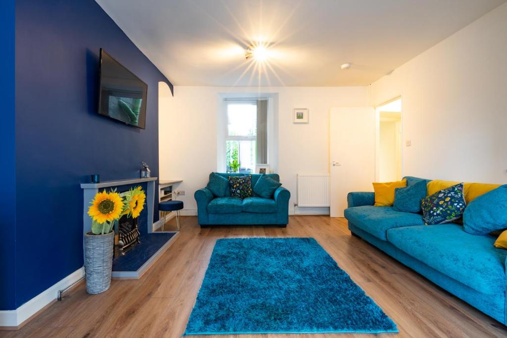un soggiorno con un divano blu e un camino di Newly-renovated, mid-terrace cottage in Porthmadog a Porthmadog