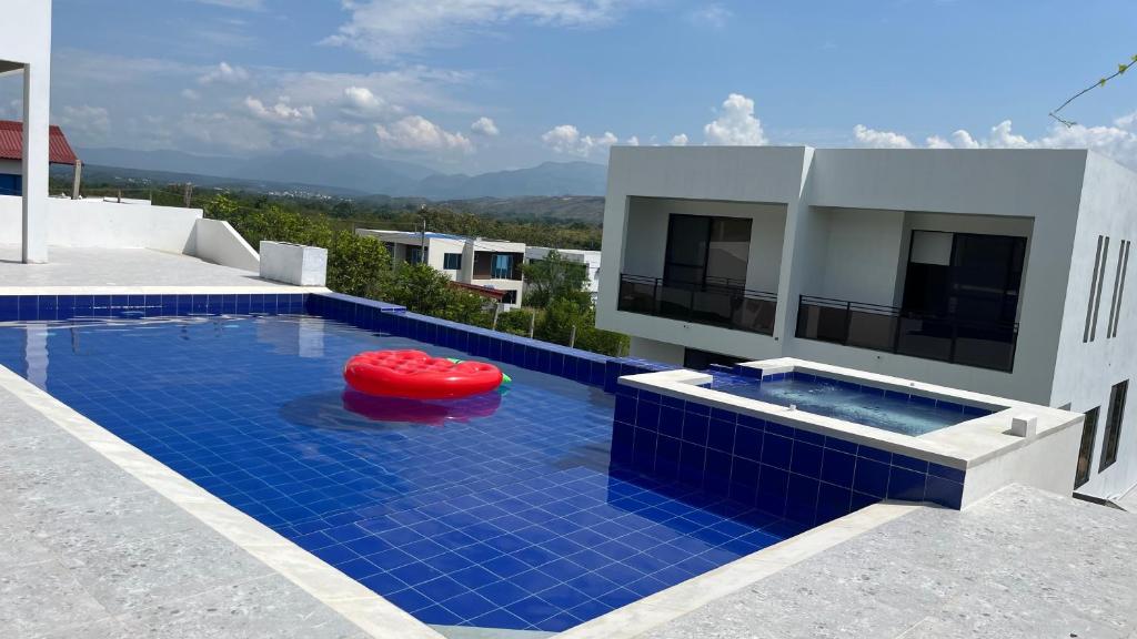 a swimming pool with a red frisbee in front of a house at Villa Nila in Carmen de Apicalá
