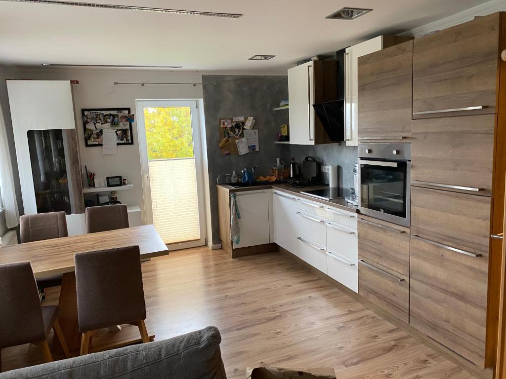 cocina con mesa de madera y cocina con comedor en Wohnhaus City Süd en Herzogsdorf