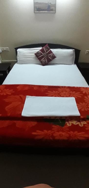 two beds with white sheets and a red blanket at Apartment Home Stay in Bangalore