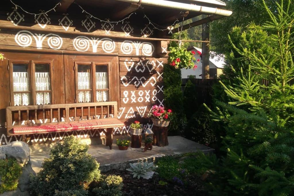 un modelo de casa con banco y plantas en Maľovaná drevenička v Čičmanoch en Čičmany