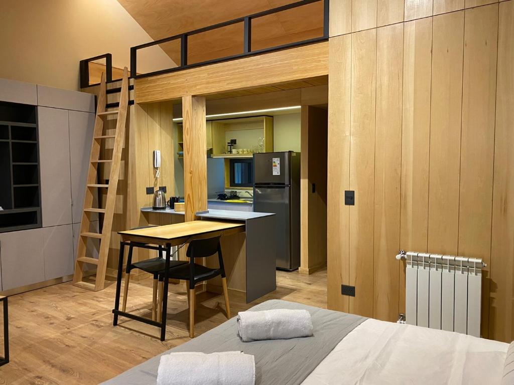 a bedroom with a loft bed and a kitchen with a desk at VIVERO 5 SMA in San Martín de los Andes