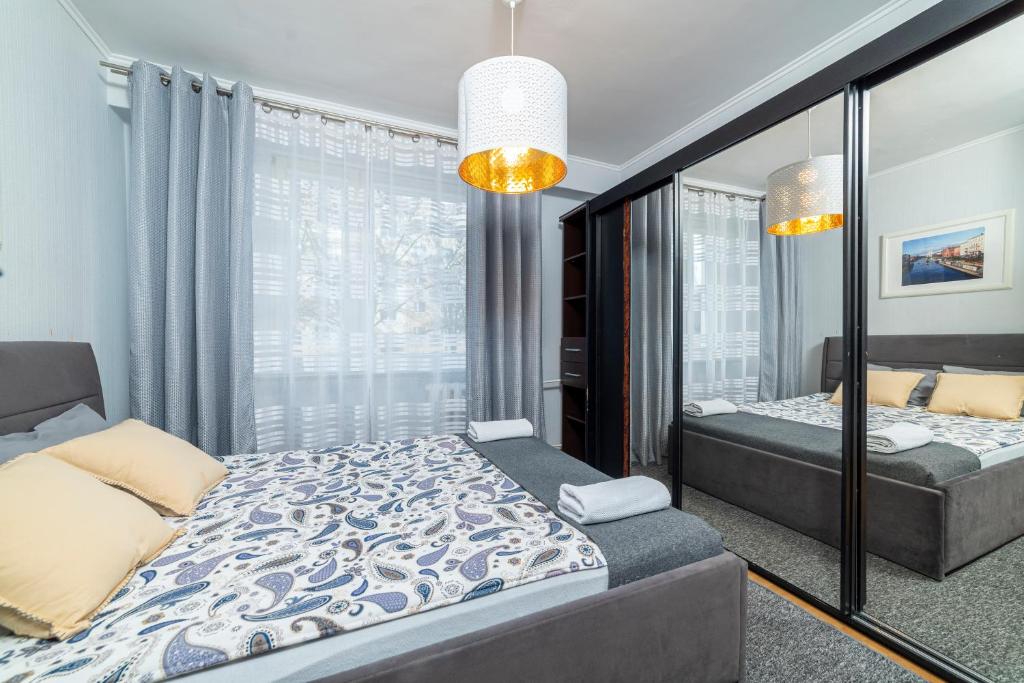 een slaapkamer met een bed en een spiegel bij Apartament Gersona 4 in Bydgoszcz