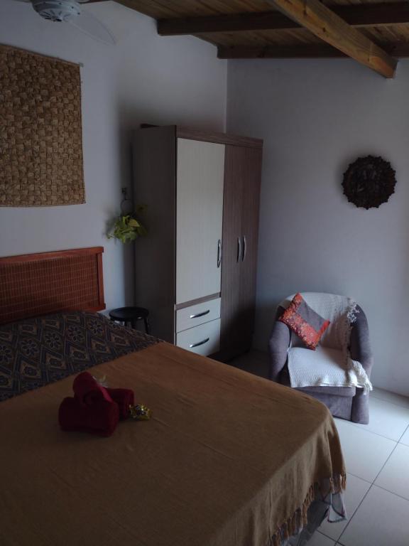 a bedroom with a bed and a cabinet and a chair at Apartamento - Praia da Ferrugem com Espaço Gourmet in Palhocinha
