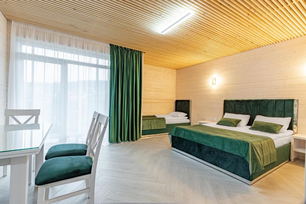 a bedroom with two beds and a table and a chair at Milana SPA & Hotel - SPA included in Bukovel