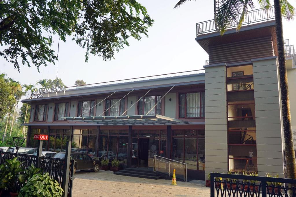 a building with cars parked in front of it at Saugandhika West Gate in Wayanad