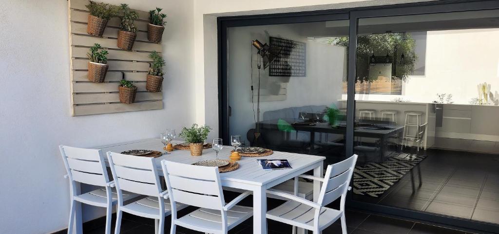 a white table with white chairs in a room at Casilla de Costa, La Oliva in Villaverde