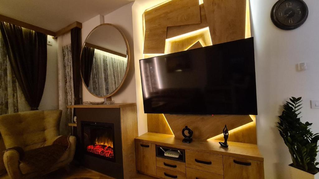 a living room with a television and a fireplace at Palace 15 in Zlatibor