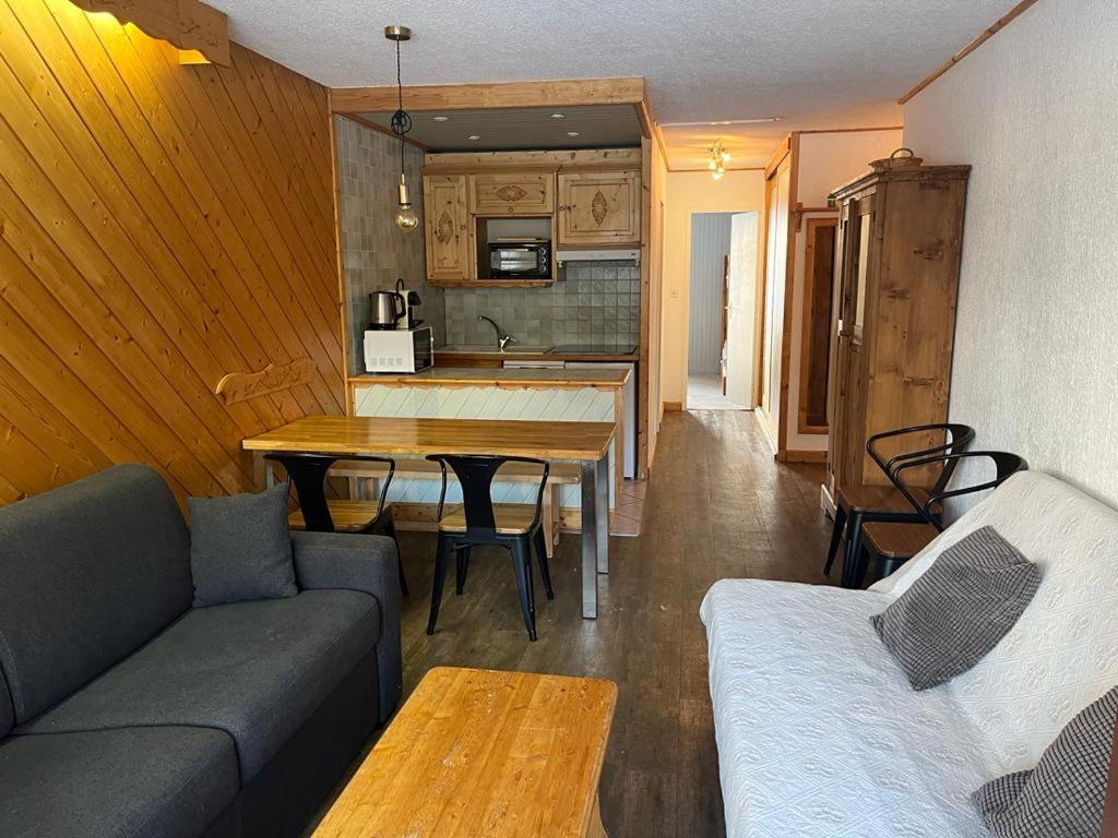 ein Wohnzimmer mit einem Sofa und einem Tisch sowie eine Küche in der Unterkunft Grand 2 pièces traversant au Val Claret, 4 à 6 pers in Tignes