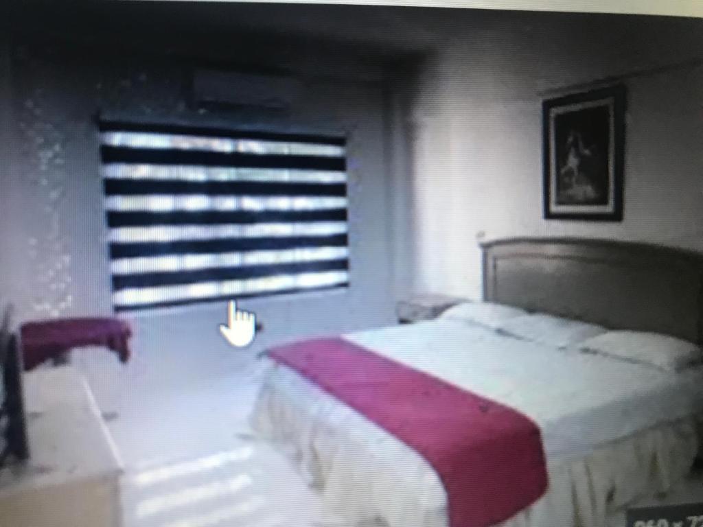 Un dormitorio con una cama grande y una ventana en Xiomara, en Quito