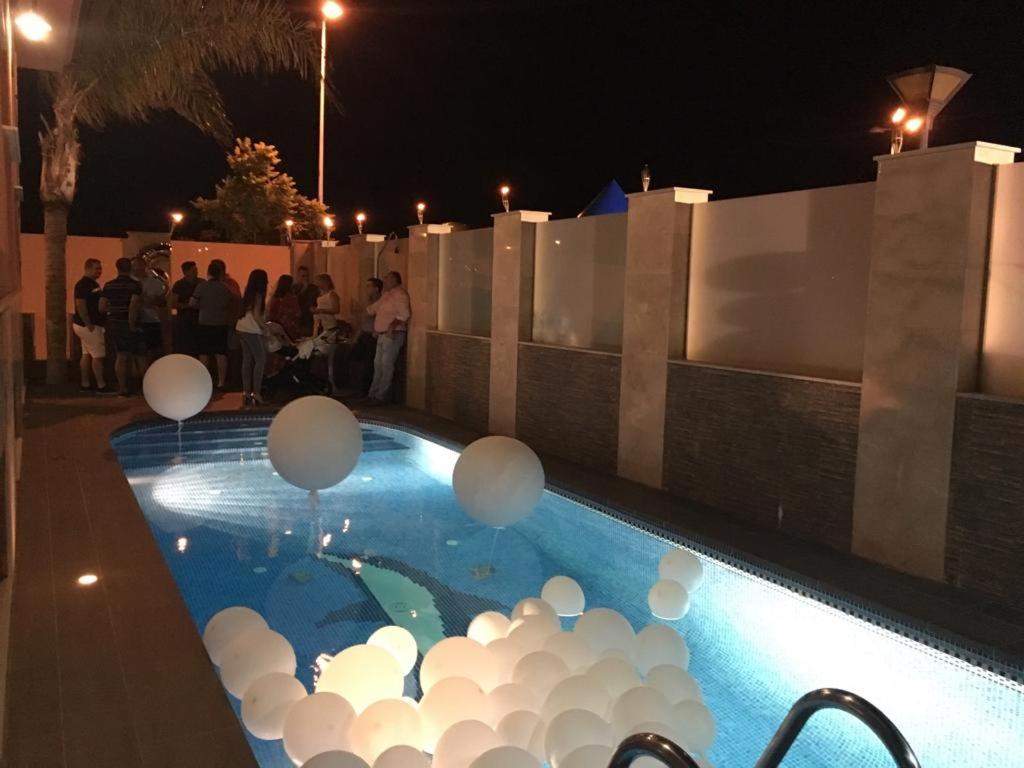 una piscina con palloncini bianchi di notte di Chalet de lujo a Pulpí